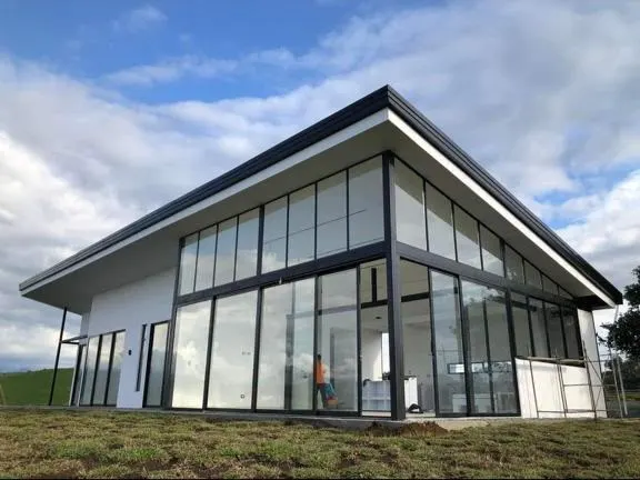 Fachada de casa con ventanales de aluminio negro y cristal